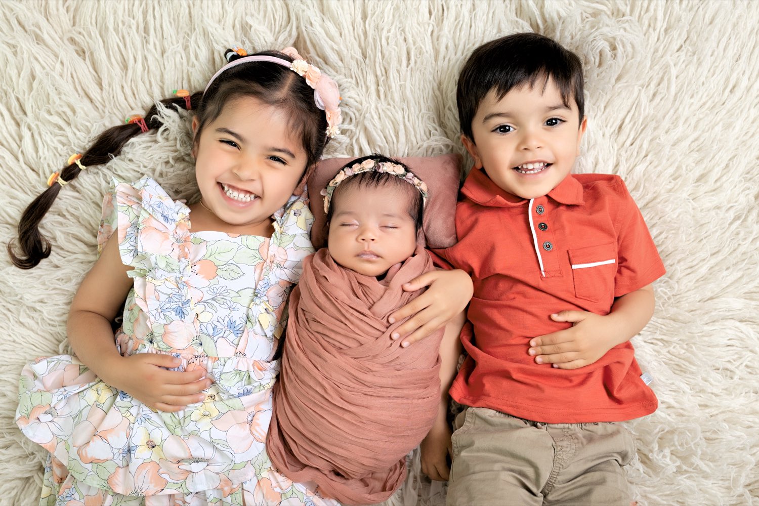 Three young children smiling together