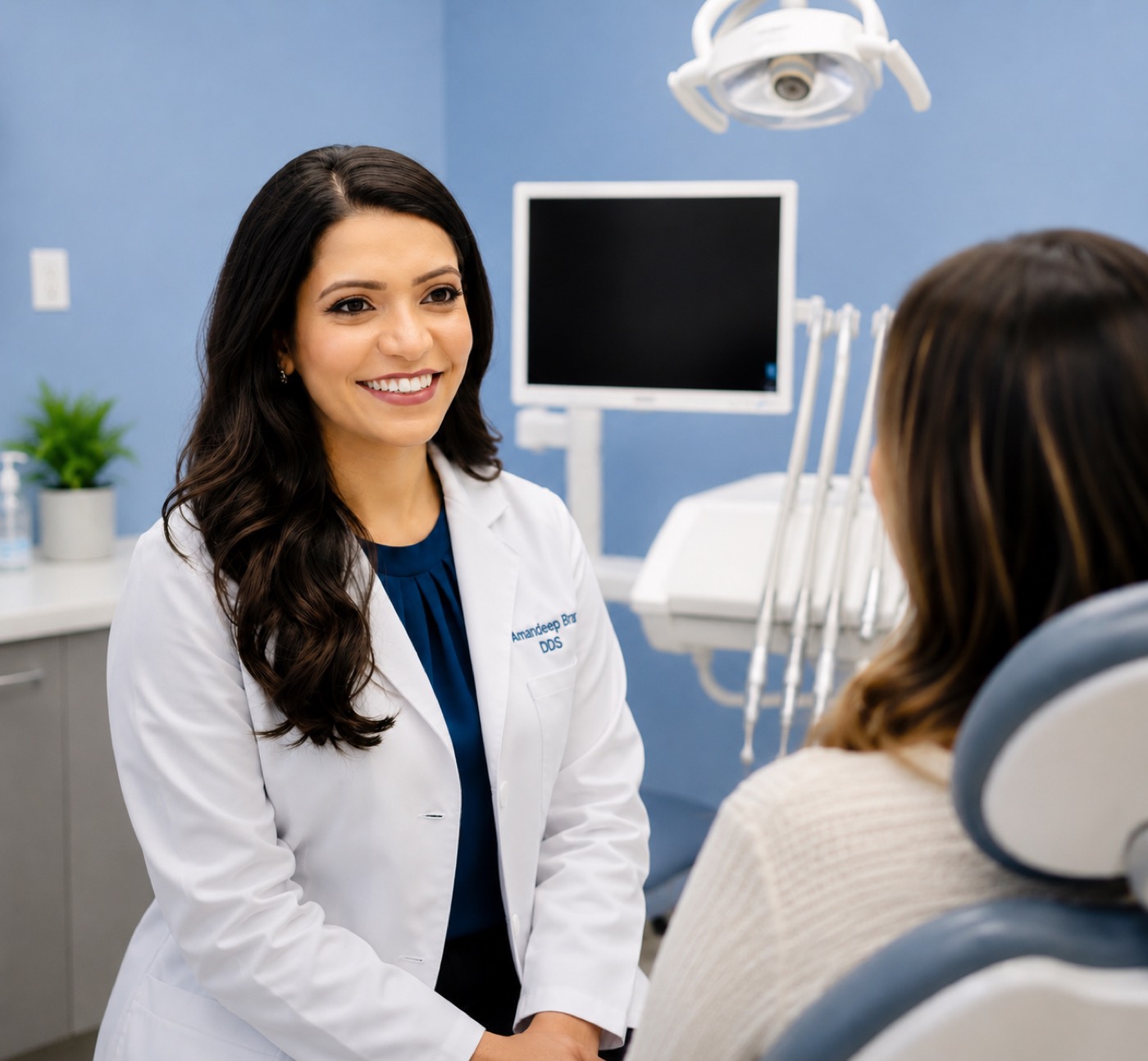 Dr. Amandeep Brar talking with a patient in the treatment room at Blue Petal Dental in Mountain House